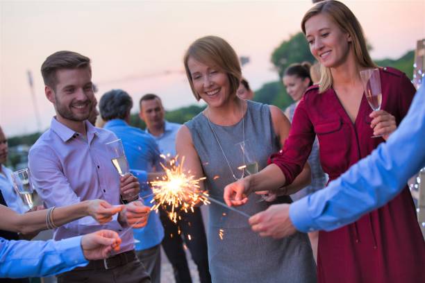 istock Smiling business colleagues holding sparklers during party on rooftop 1191845421