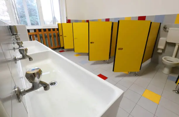taps of washbasin and yellow doors in the bathroom of a nursery school without children