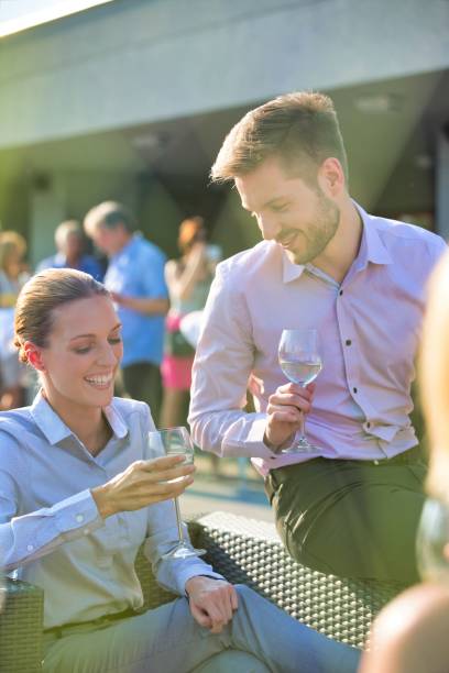 istock Young business colleagues talking while sitting with wineglasses at rooftop party 1191846977
