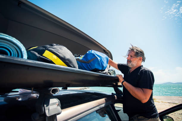 istock Men Packing Cargo Box Container on Roof Rack On Vacations 1191847175