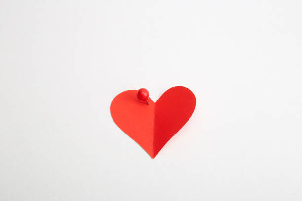 istock Red heart paper with red pin on white 1191848546
