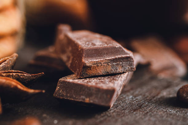 istock Chopped dark chocolate cubes on wooden board, close-up view 1191848687