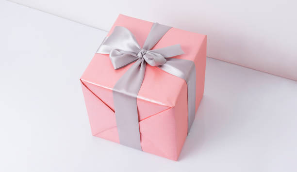 istock Pink presents with silk ribbon on white background 1191852020