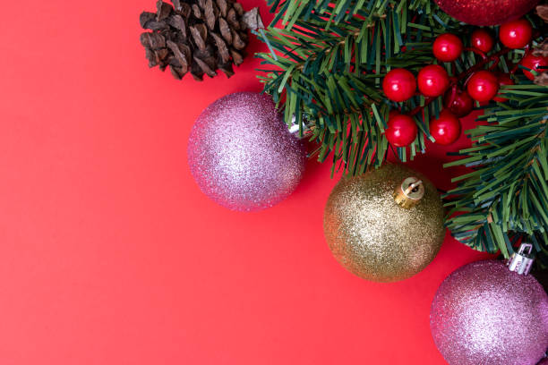istock Christmas Decorations on red background, Christmas border with cedar leaf, pine cones and baubles. 1191852741