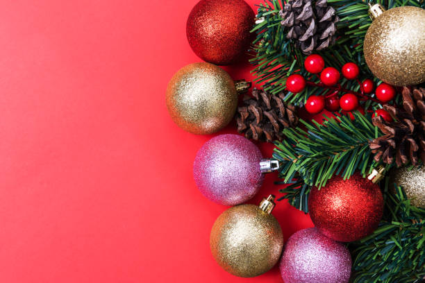 istock Christmas Decorations on red background, Christmas border with cedar leaf, pine cones and baubles. 1191852797