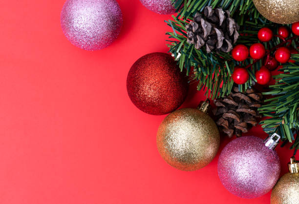 istock Christmas Decorations on red background, Christmas border with cedar leaf, pine cones and baubles. 1191853344
