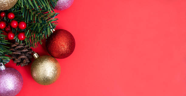 istock Christmas Decorations on red background, Christmas border with cedar leaf, pine cones and baubles. 1191853364