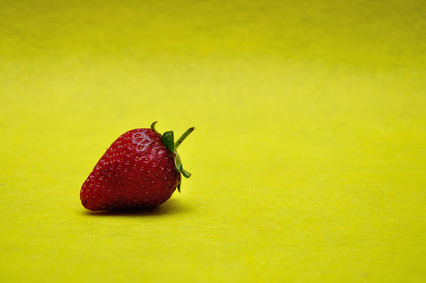 istock A strawberry on a yellow background 1191853566