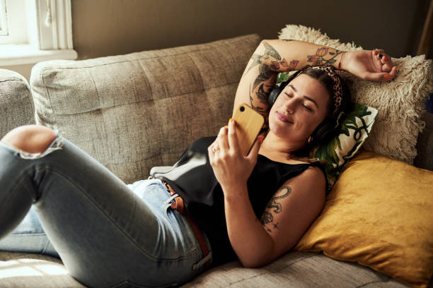 для каждого настроения есть музыка, чтобы соответствовать - headphones women tattoo music стоковые фото и изображения