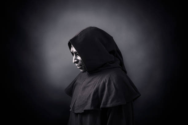 istock Scary figure in hooded cloak with mask 1191856509