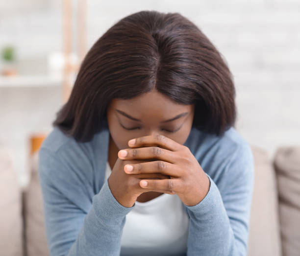 istock Depressed black woman sitting alone at home, feeling desperate 1191856510