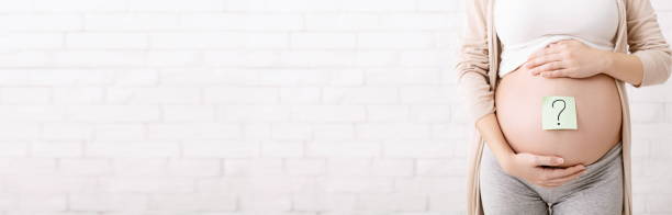 istock Pregnant woman belly with question mark, panorama 1191856535