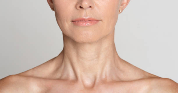 Skin care. Half face portrait of mature woman Skin care. Half face portrait of mature woman with wrinkled neck, grey background, crop neck stock pictures, royalty-free photos & images