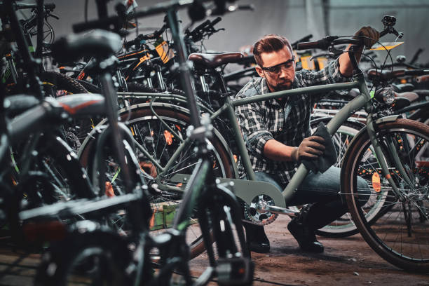 istock Busy attractive man in protective glasses is cleaning bicycle from dirt 1191856714