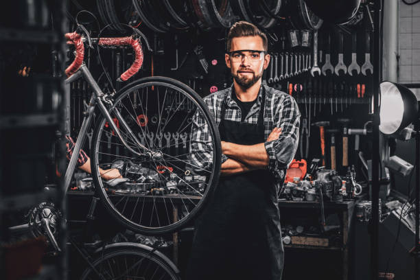 istock Handsome man in glasses is standing near fixed bicycle at his own workshop. 1191857525
