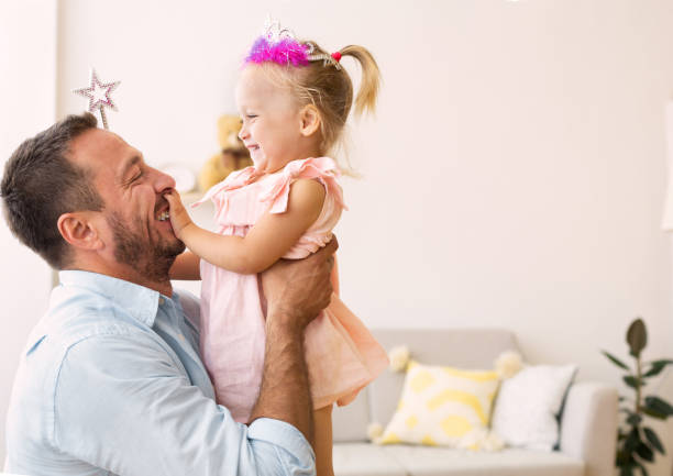 istock Happy daughter in crown playing with father 1191857616