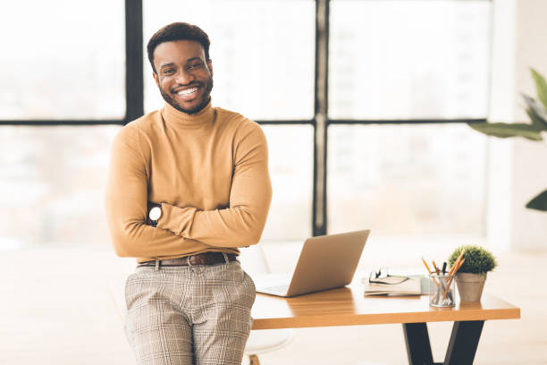 istock Successful black man sitting on desk at office 1191857906
