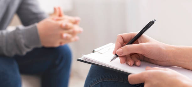 Therapist writing notes during rehab session with patient Therapist writing notes during rehab session with patient, panorama, empty space pessimism photos stock pictures, royalty-free photos & images