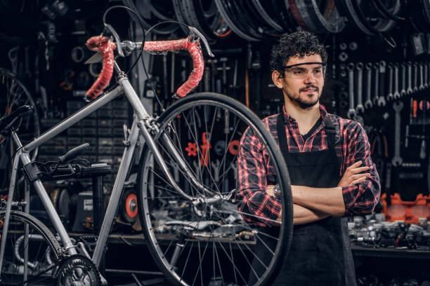 istock Smiling man in glasses is standing near fixed bicycle at his own workshop. 1191858040