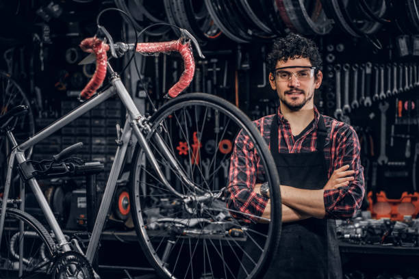 istock Smiling man in glasses is standing near fixed bicycle at his own workshop. 1191858061