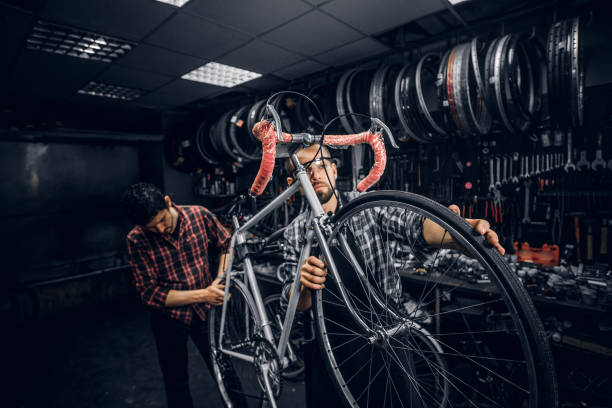 istock Two attractive mans are working on bicycle fixing at busy workshop 1191858085