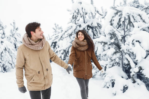istock Happy Spouses Walking Holding Hands Through Winter Forest 1191858651