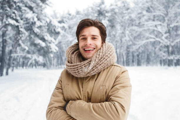 istock Attractive Man Smiling At Camera Posing In Snowy Forest 1191859476