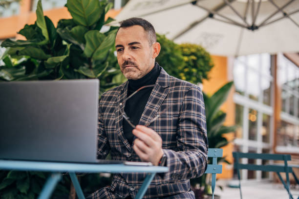 istock Gentleman using laptop outdoors in cafe 1191860545
