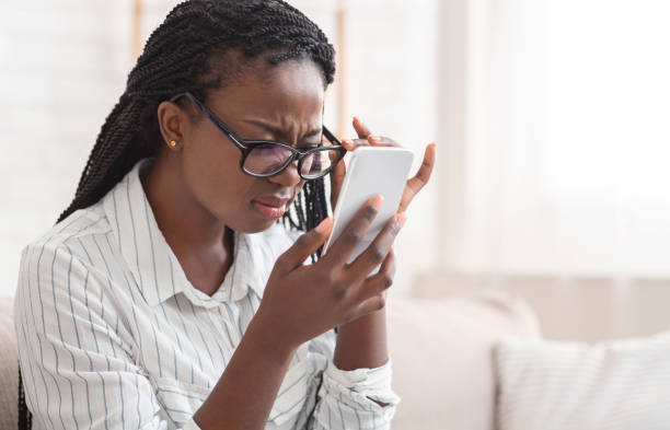 Afro Girl Looking At Smartphone Screen Through Glasses, Having Eyesight Problem Poor Eyesight Concept. Black Woman Looking At Smartphone Screen Through Glasses, Having Problems With Vision, Selective Focus myopia stock pictures, royalty-free photos & images