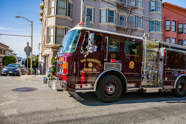 A hook and ladder fire engine truck sits in front of the fire engine house.