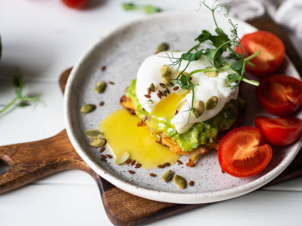 istock Healthy nutritious breakfast of potato pancake, mashed avocado, poached egg, pea sprouts and various seeds on a ceramic plate 1191864019