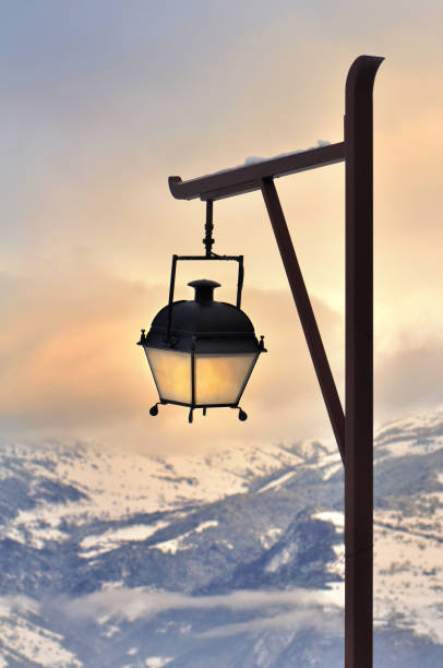 lamp post in front of a beautiful sunset in snowy mountain