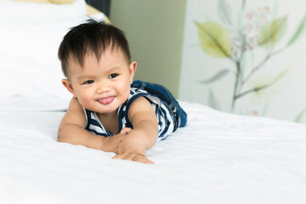 istock Cute Baby Boy Lying On Bed At Home 1191871450