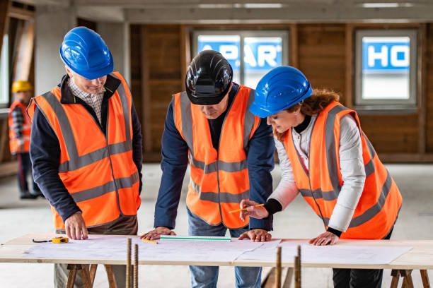 istock Foreman and forewoman discussing blueprint with architect 1191873158