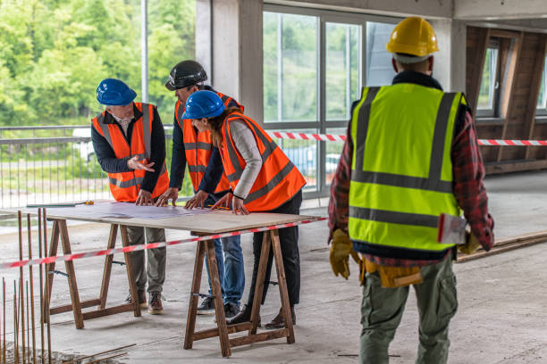 istock Foreman and forewoman discussing blueprint with architect 1191873189