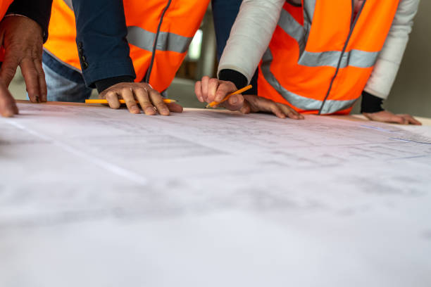 istock Foreman and forewoman discussing blueprint with architect 1191873191