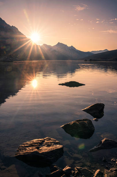 lever de soleil sur la montagne rocheuse avec des roches dans le lac de médecine au parc national de jasper - canada alberta mountain mountain range photos et images de collection