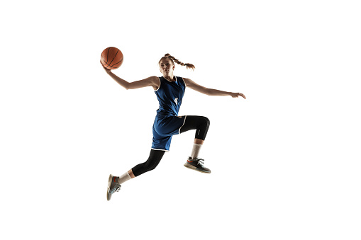 Female caucasian basketball player dribbling ball while training at indoor court front medium shot side view
