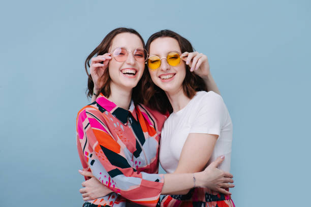 The girls united, they hugged tightly and holding each other's glasses Feminism concept. The girls united, they hugged tightly and holding each other's glasses twin stock pictures, royalty-free photos & images