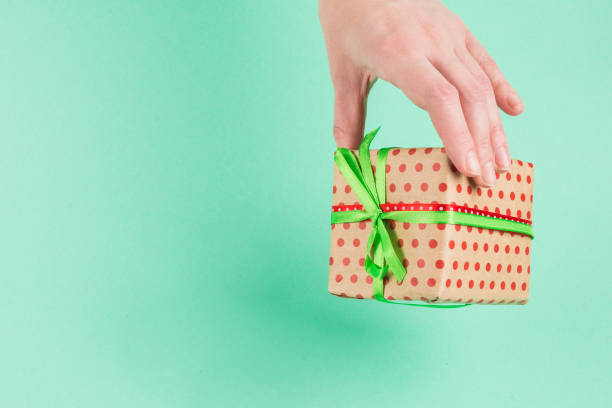 istock Present in woman hand on a green background. 1191879108