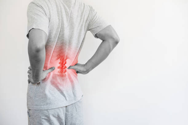 Office syndrome, Backache and Lower Back Pain Concept. a man touching his lower back at pain point stock photo