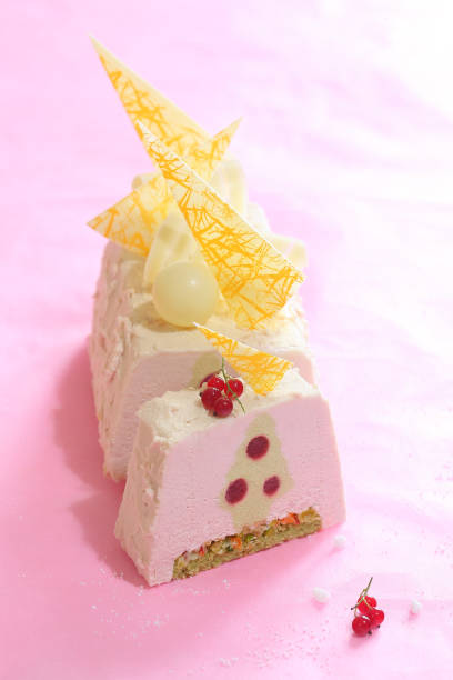 Contemporary Pistachio and Red Currant Yule Log Cake stock photo