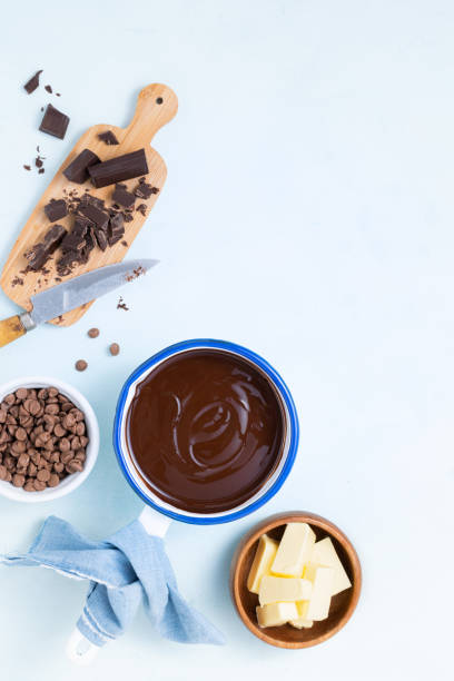 istock Molten chocolate with different types of chocolate for dough preparation recipe chocolate ganache, cake, brownie, muffins, cupcakes ingridients, food flat lay on light background. Text space. 1191880185
