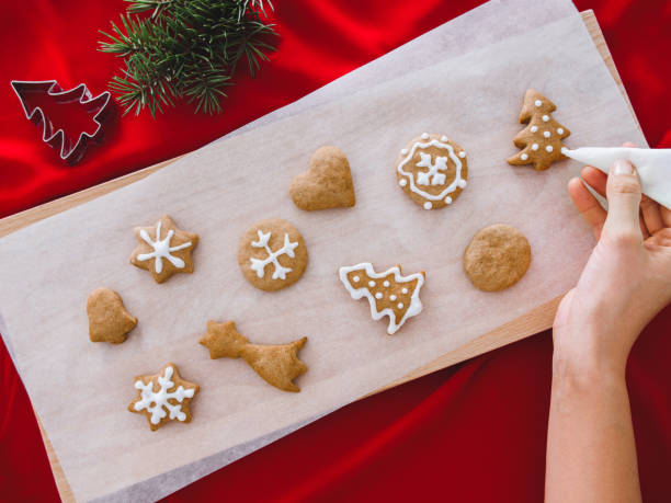 istock Christmas bakery. Man decorating freshly baked gingerbread cookies with icing and confectionery mastic. Festive food, family culinary, Christmas and New Year traditions concept 1191881908