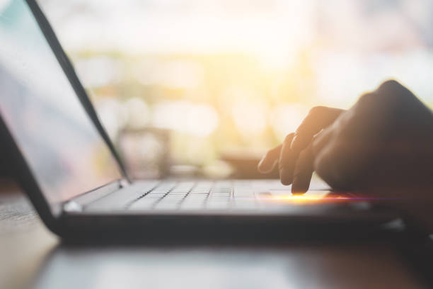 istock Man hand using keyboard laptop on wood table in coffee shop. 1191884225