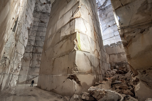 Adult Man Standing Inside Of Large Marble Quarry.