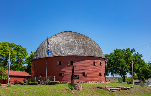 Arcadia, Oklahoma, USA. May 13, 2019. Arcadia round barn, a landmark next to route 66. The old construction of red oak boards and the grey roof is an attraction for the tourists.