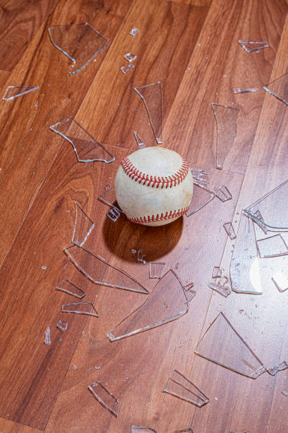 istock Looking down on a baseball with broken glass from a window on the floor 1191888775