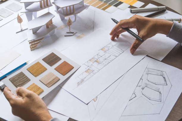 architect design working drawing sketch plans blueprints and making architectural construction model in architect studio stock photo