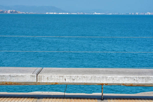 Close-up view of a public bench on the footbridge leading to the marina of Valencia